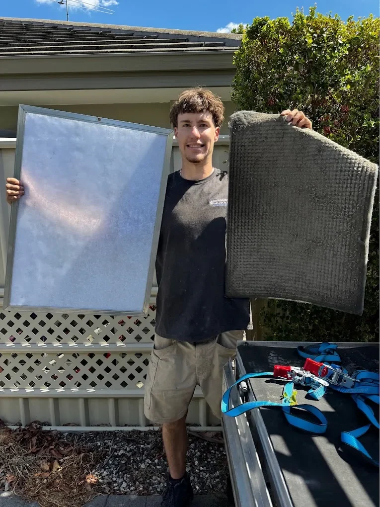 Technician holding a clean and a heavily soiled air-conditioning filter for comparison