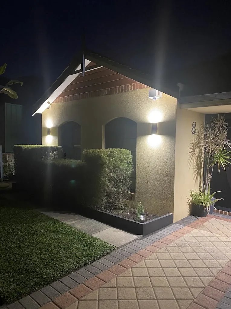Completed exterior lighting installation illuminating a residential entrance at night